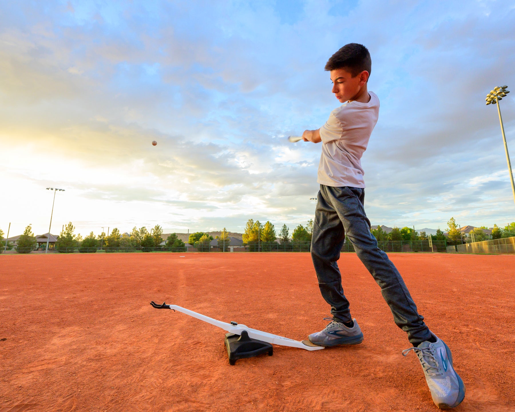 Boy hitting baseball using Stomp-Toss